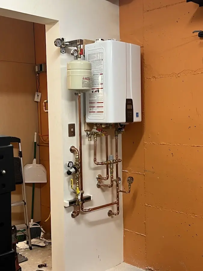 Plumbing technician inspecting water heater connections in Greenville